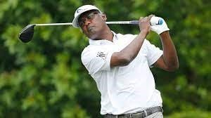 Vijay Singh in a white hat, white shirt, and white left glove at the base of the club